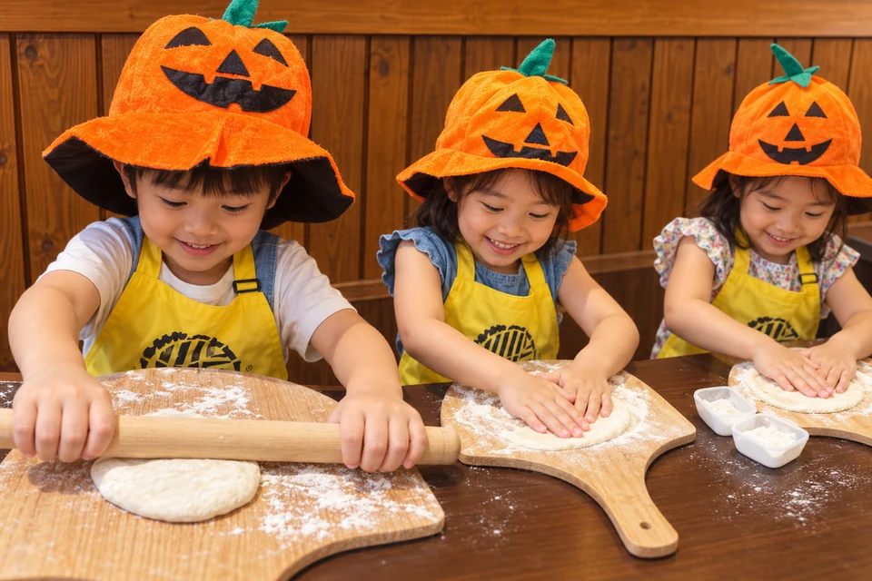 萬聖親子DIY後製示意：孩子戴南瓜帽開心製作披薩